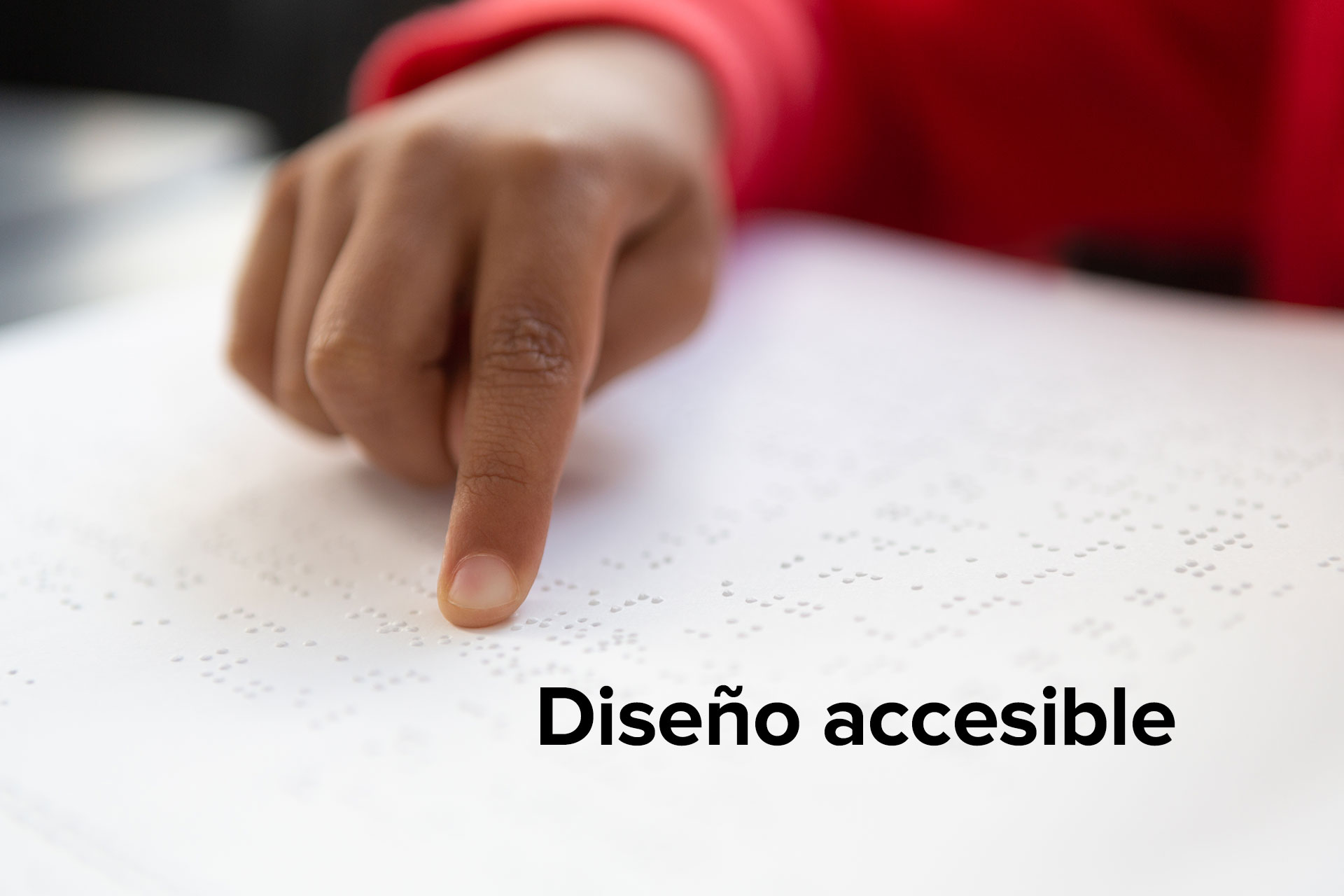 Mano de una persona sobre una página con escritura braille